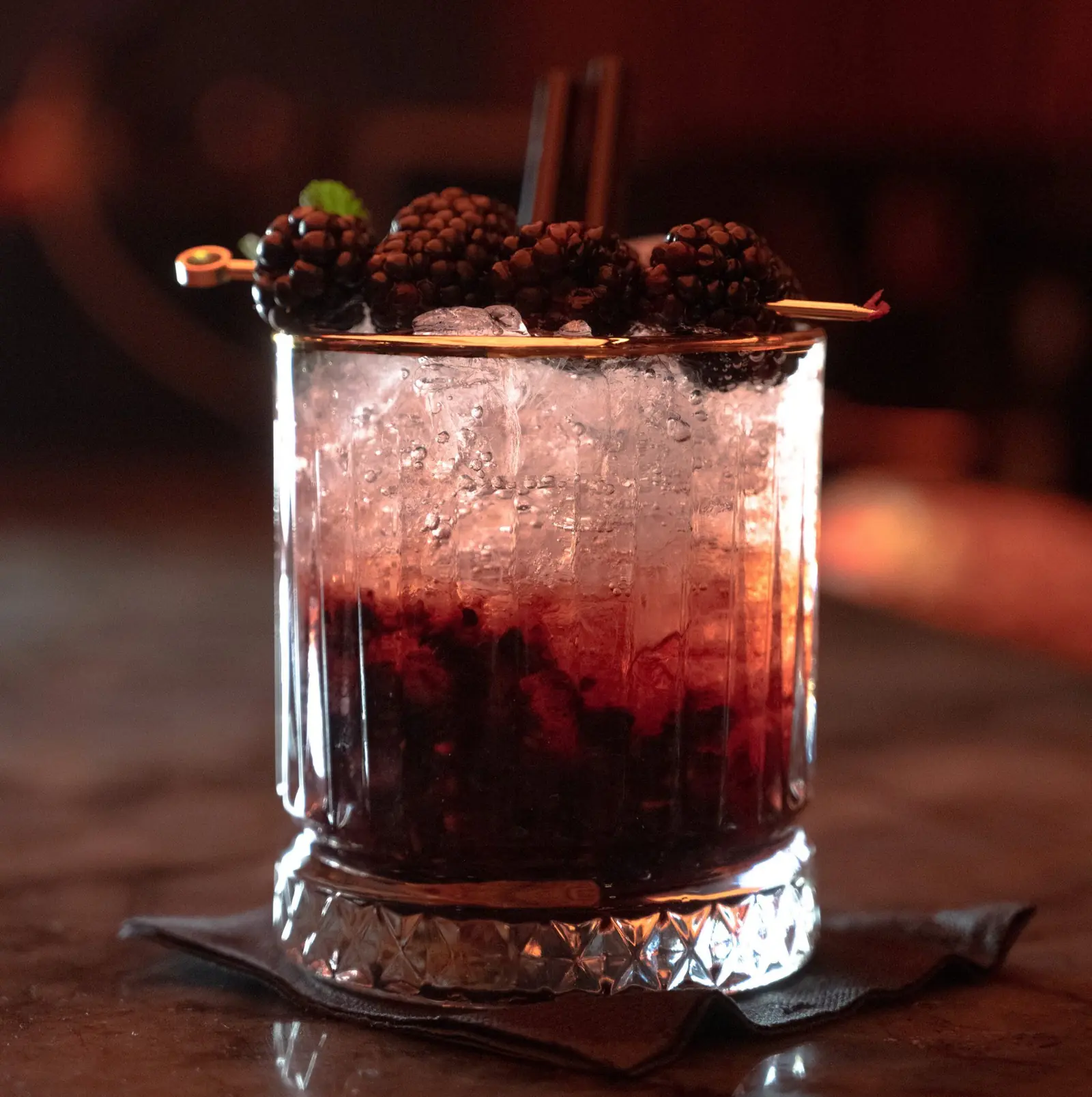 Een cocktail met bramen op crushed ijs