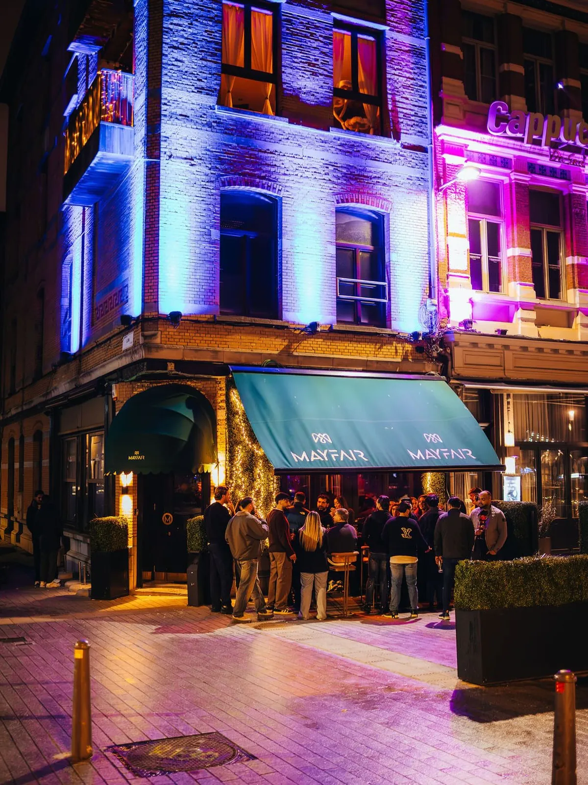 The facade of Mayfair at night on the corner of Luikstraat and Waalse Kaai