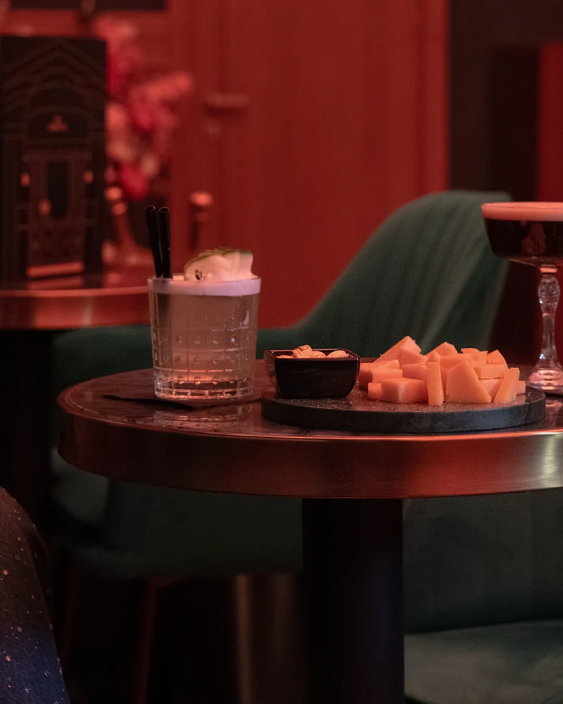 A table with cocktails and bites in the green velvet room