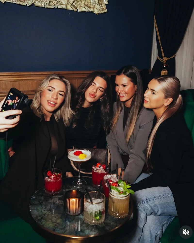 A group with cocktails at a table at Mayfair