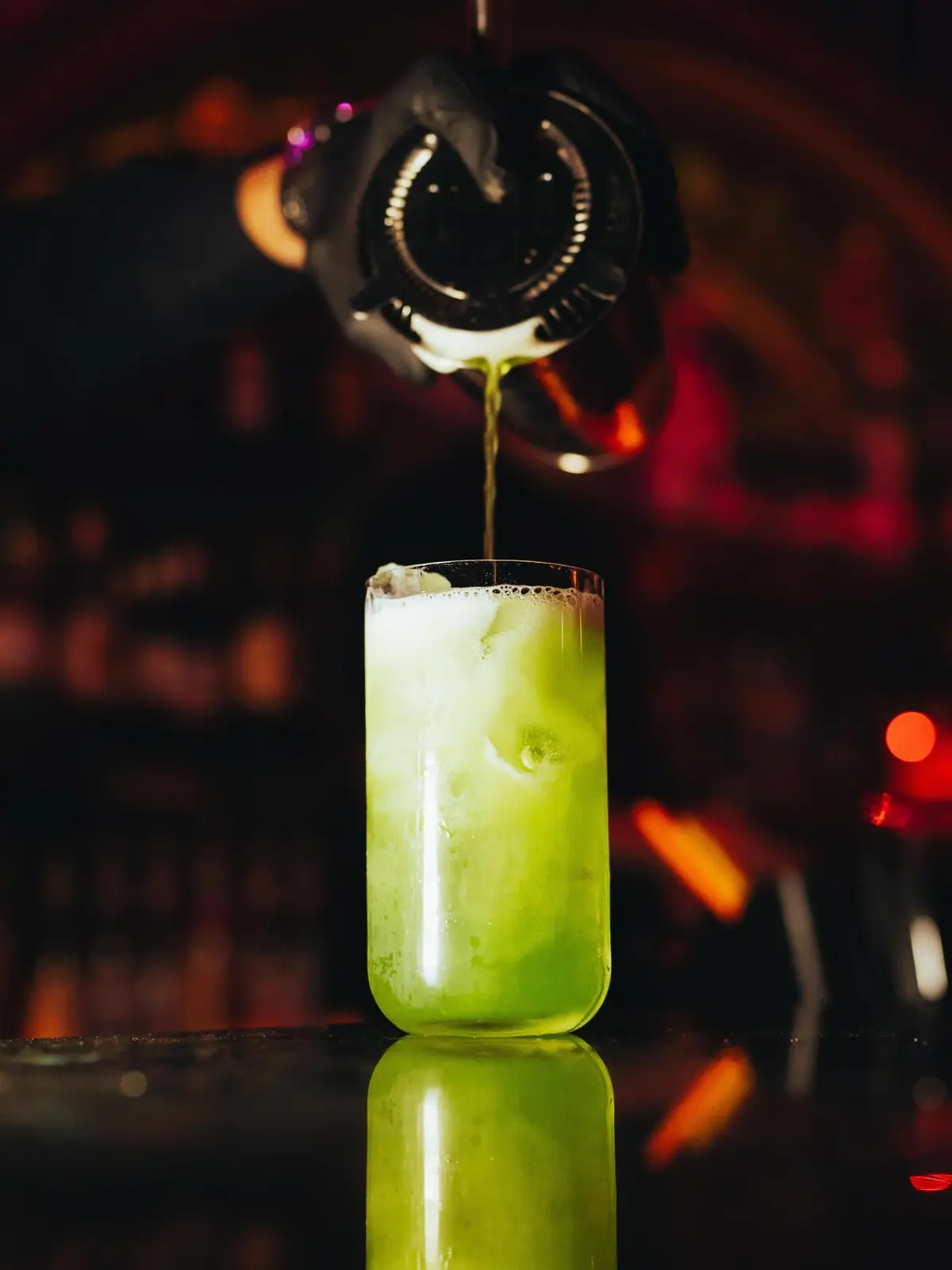 Een groene cocktail wordt ingeschonken aan de toog