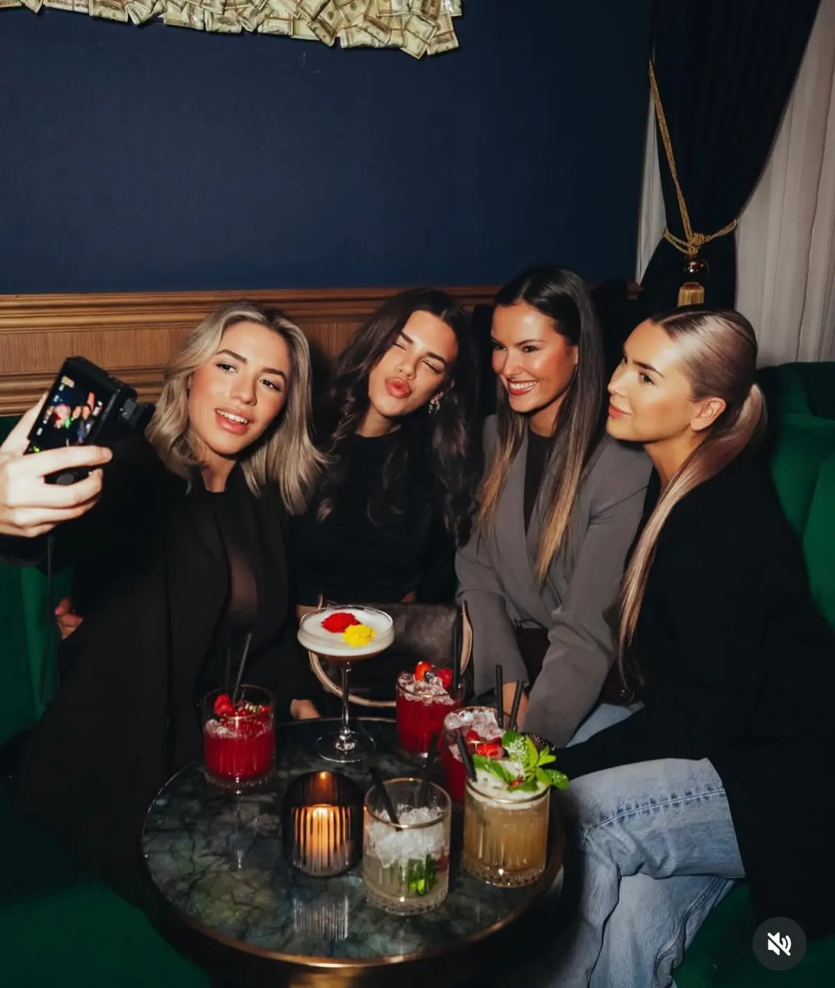 Een groep met cocktails aan een tafel bij Mayfair