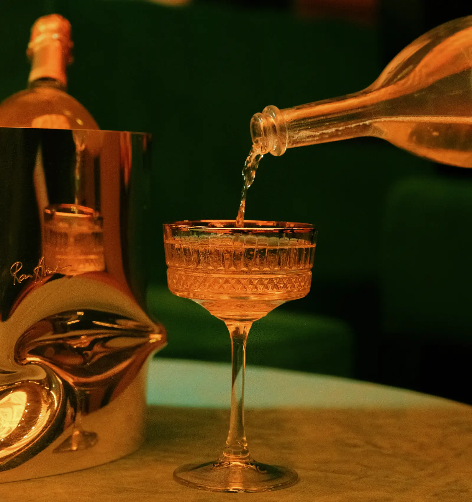 Champagne wordt ingeschonken in een coupe naast een zilveren ijsemmer bij Mayfair